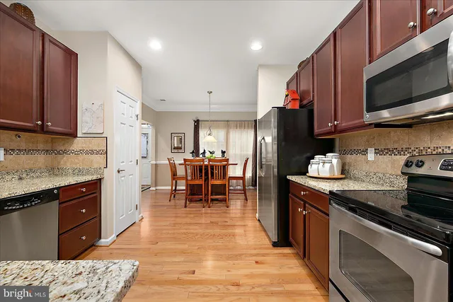 a kitchen with stainless steel appliances granite countertop a refrigerator and a sink