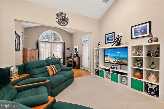 a living room with furniture kitchen view and a chandelier