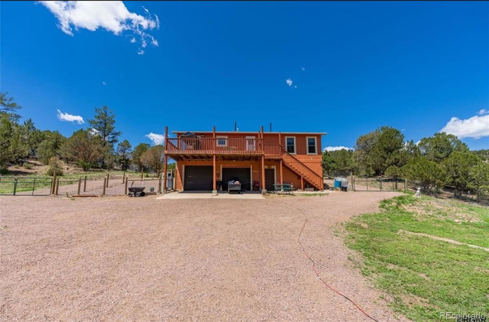 7878 Copper Gulch Road Cotopaxi, CO 81223 - Photo 9 of 17 a front view of a house with a yard and garage