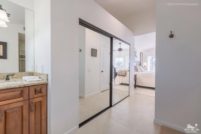 a en suite bathroom with a granite countertop sink and a mirror