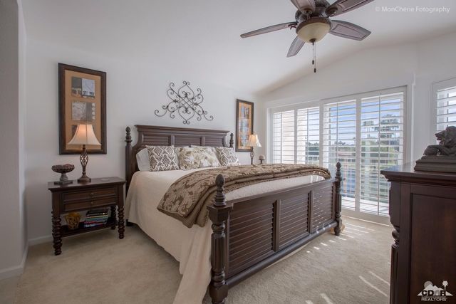 a spacious bedroom with a bed and a chandelier