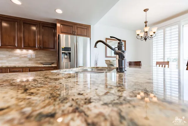 a view of a kitchen with granite countertop a sink and cabinets