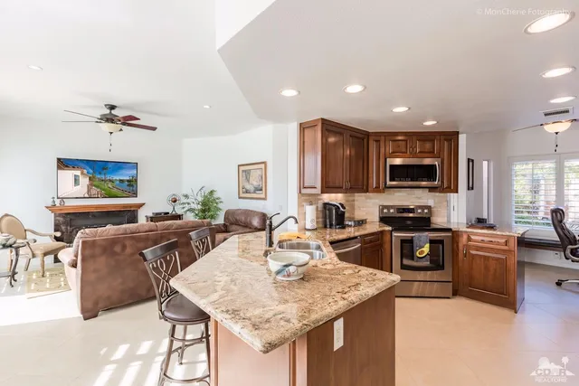 a kitchen with a stove a sink a microwave a dining table and chairs