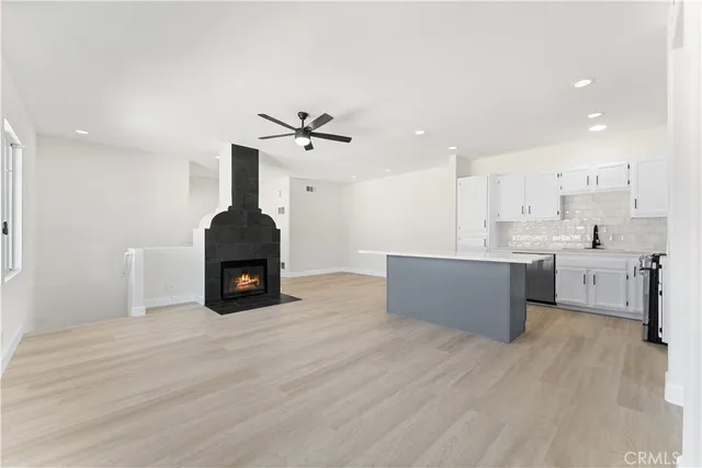 an empty room with windows and ceiling fan