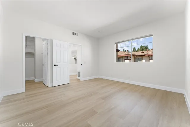 an empty room with windows and closet