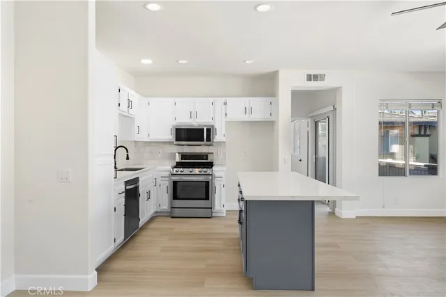 a kitchen with stainless steel appliances a stove a sink and a refrigerator