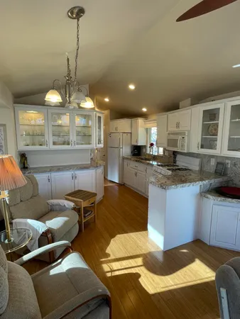 a large kitchen with a lot of cabinets appliances and furniture
