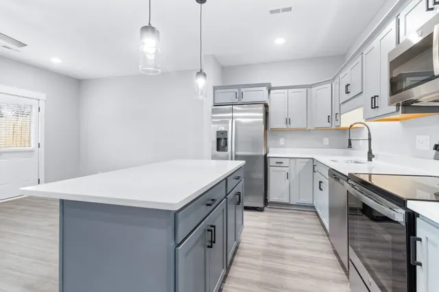 a kitchen with stainless steel appliances granite countertop white cabinets a sink and dishwasher