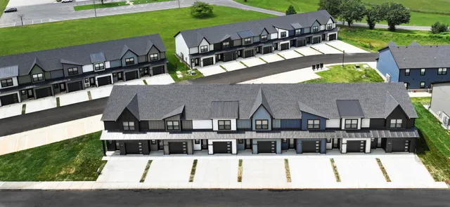 a view of a big house with a big yard plants and large trees