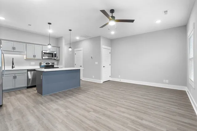 a kitchen with kitchen island a sink stainless steel appliances and cabinets