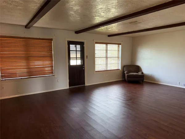 a view of a livingroom with wooden floor and a window