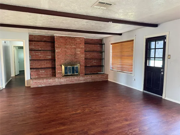 wooden floor in an empty room with a fireplace