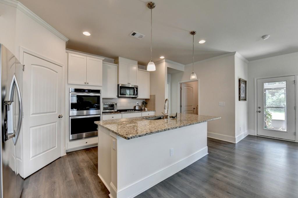 7535 Rambling Vale Dawsonville, GA 30534 - Photo 19 of 69 a large kitchen with stainless steel appliances granite countertop a stove a refrigerator a sink a microwave and wooden floor