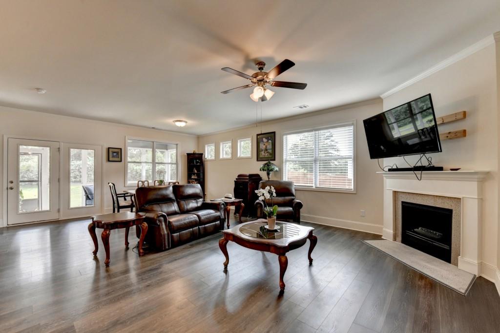 7535 Rambling Vale Dawsonville, GA 30534 - Photo 31 of 69 a living room with furniture a fireplace a flat screen tv and wooden floor