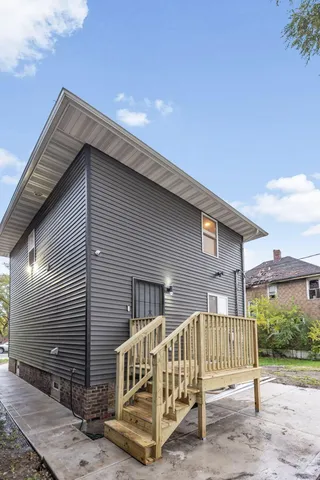 a view of a house with a small yard and wooden fence