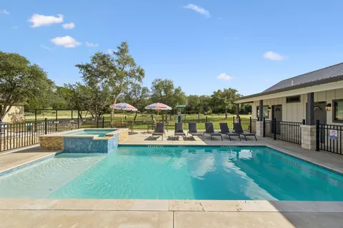 a view of swimming pool with a garden and patio