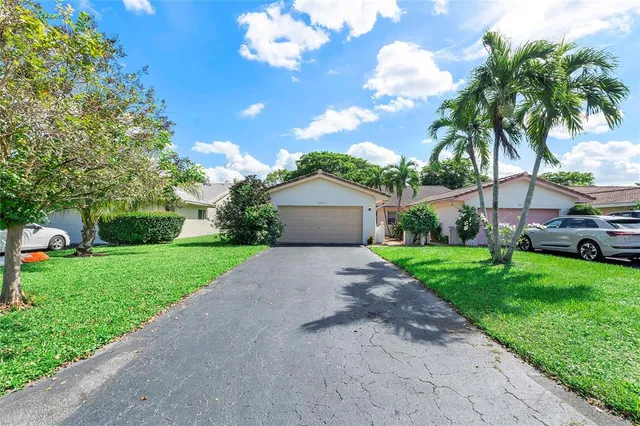 a view of a house with a yard and a large tree