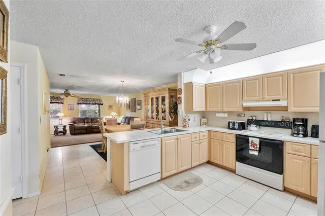a kitchen with white cabinets a sink dishwasher and a stove