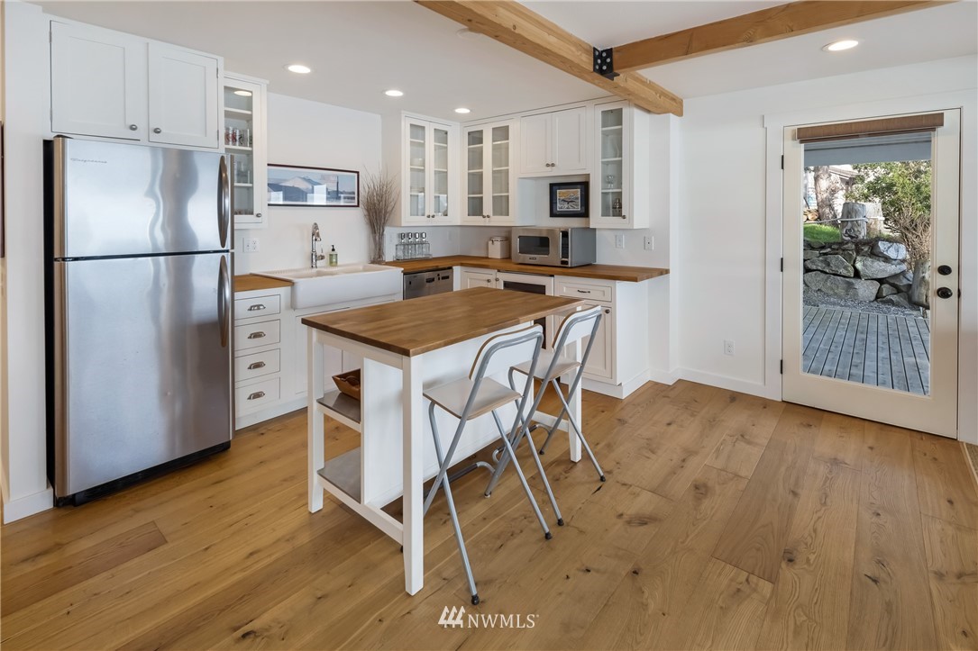 3051 Pear Point Road Friday Harbor, WA 98250 - Photo 25 of 39 a kitchen with stainless steel appliances refrigerator wooden floor dining table and chairs