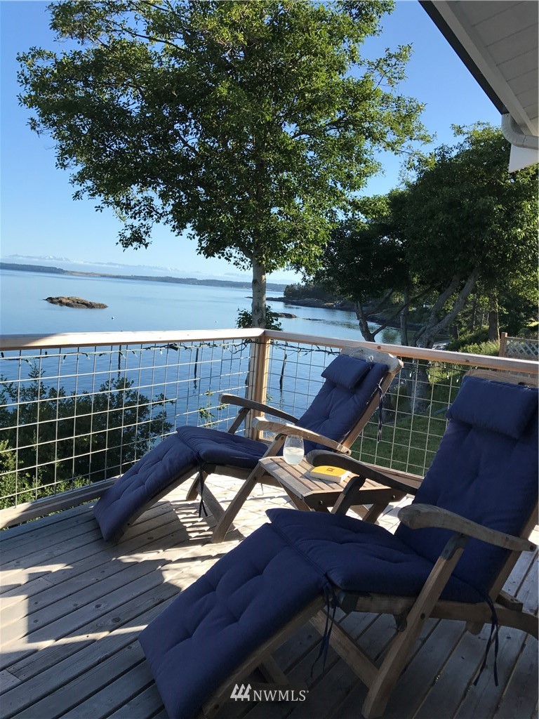 3051 Pear Point Road Friday Harbor, WA 98250 - Photo 33 of 39 a view of a roof deck with table and chairs with wooden floor and fence
