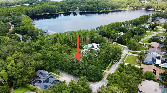 an aerial view of a house with a yard and lake view