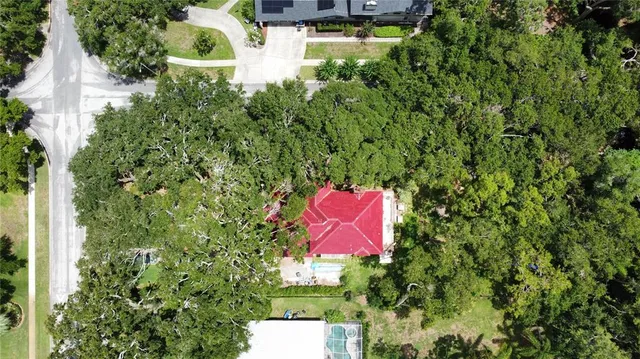 an aerial view of a house with swimming pool and garden