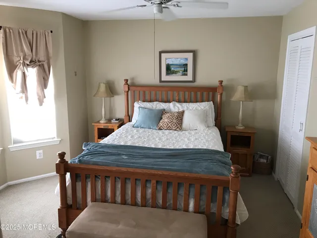 a bedroom with a bed a window and a chandelier