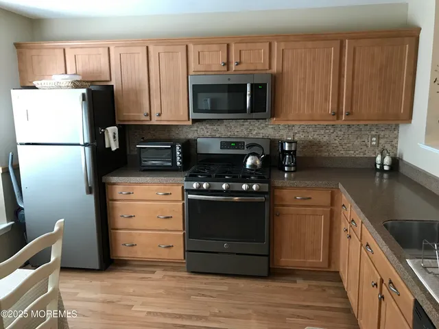 a kitchen with granite countertop a refrigerator stove and microwave
