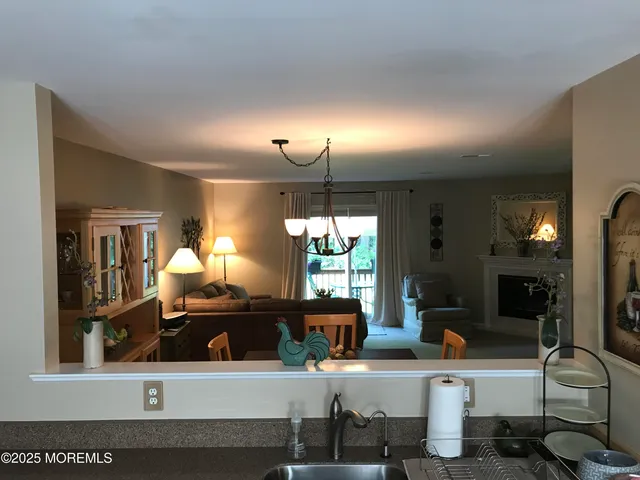 a kitchen with a sink a counter top space and living room view