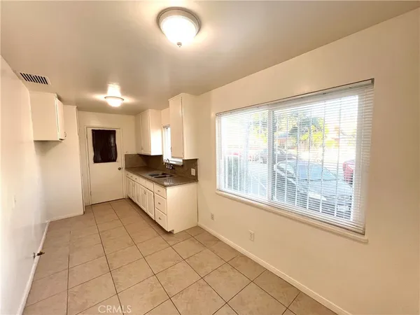 a large white kitchen with a large window