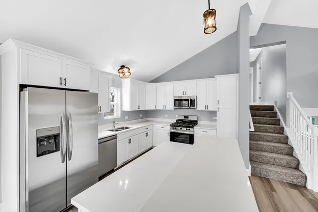 a kitchen with stainless steel appliances a refrigerator sink and stove