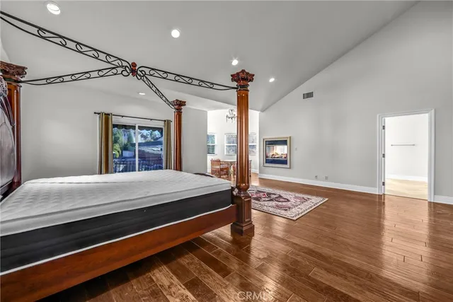 a dining room with wooden floor a chandelier a wooden table and chairs