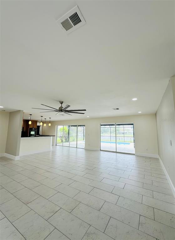 342 Severin Road Southeast Port Charlotte, FL 33952 - Photo 3 of 22 a view of empty room with wooden floor and fan