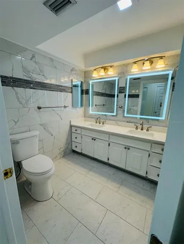 a bathroom with a sink double vanity and a toilet