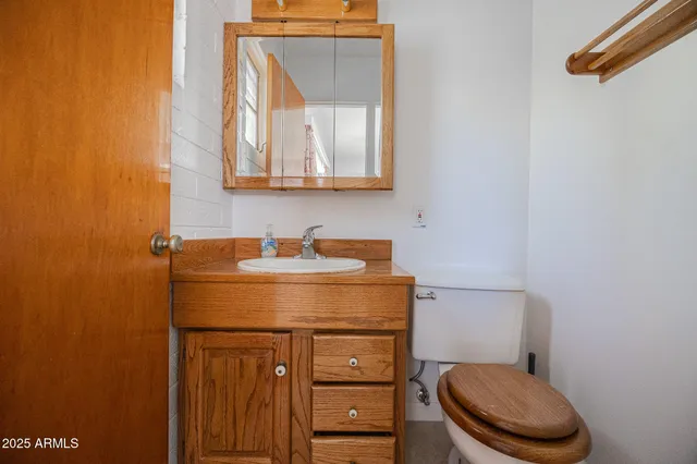 a bathroom with a granite countertop toilet sink and mirror