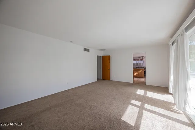 an empty room with closet and windows