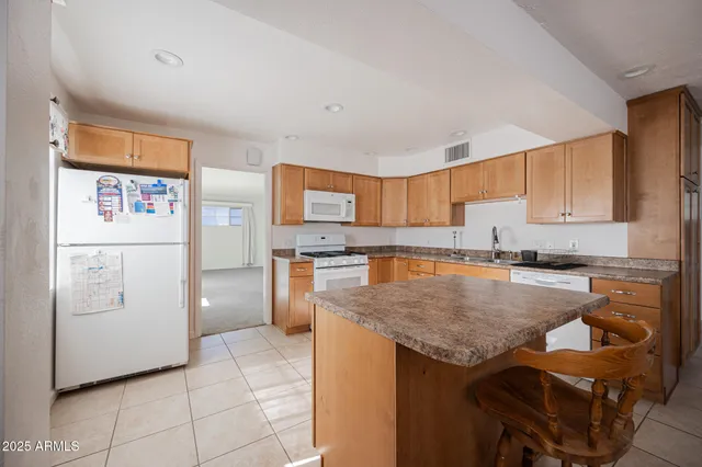 a kitchen with a refrigerator a stove a sink and cabinets