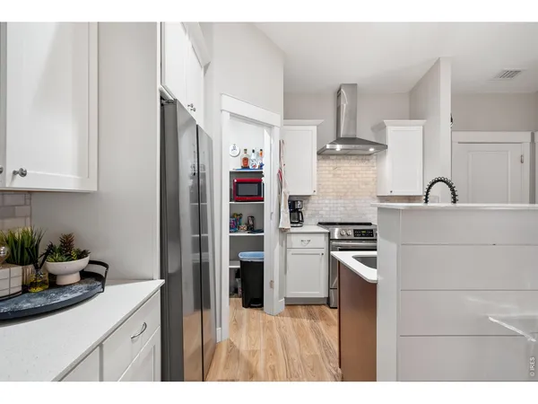 a kitchen with stainless steel appliances kitchen island granite countertop a refrigerator and a sink