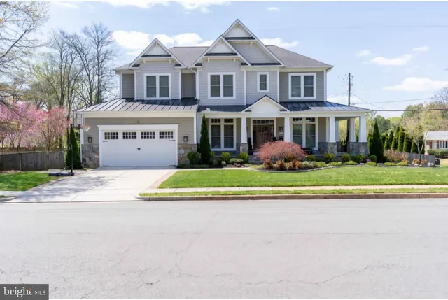 a front view of residential houses with yard and trees