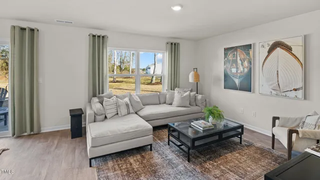 a living room with furniture a large window and a potted plant