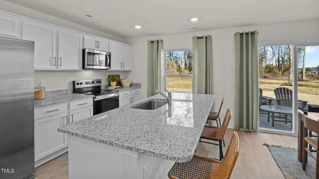 a kitchen with stainless steel appliances granite countertop a stove top oven a sink dishwasher and cabinets with wooden floor