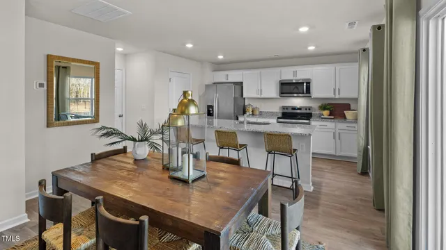 a open dining room with kitchen island a table and chairs