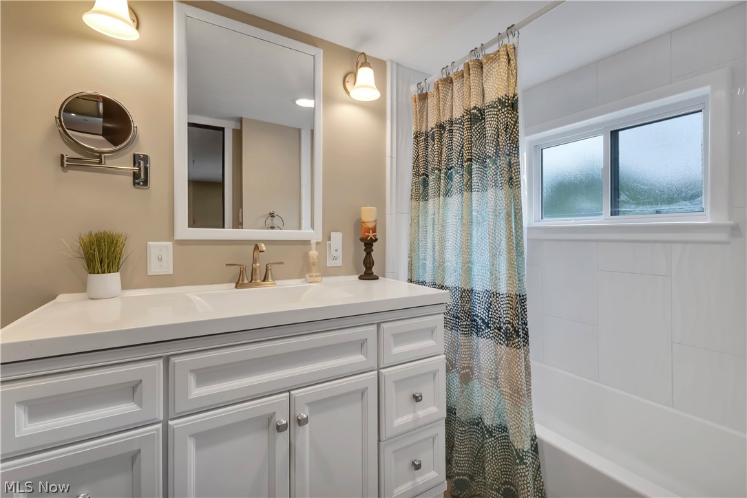 8704 Columbia Road Olmsted Falls, OH 44138 - Photo 14 of 34 White vanity with shaker-style cabinetry, an integrated sink, and a light-toned countertop