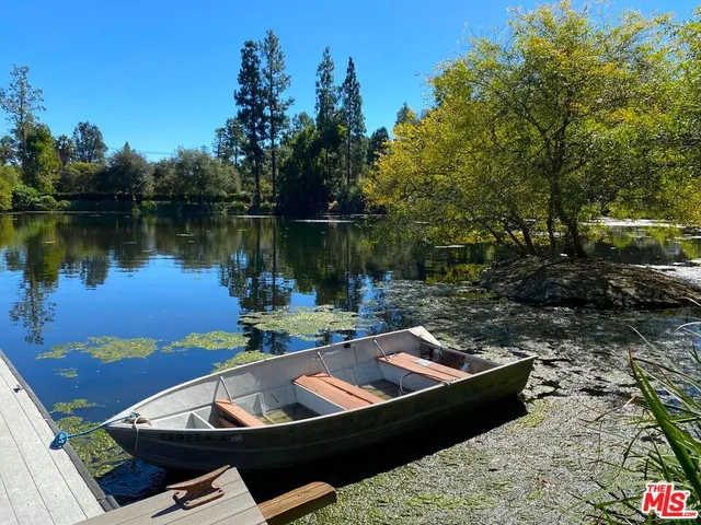 a view of a lake with a yard and large trees