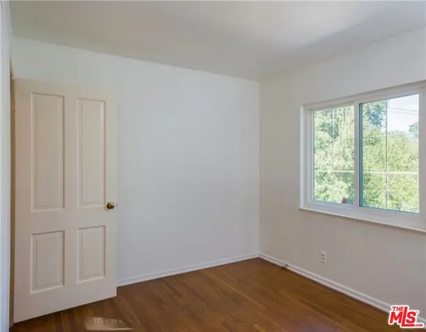 a view of a chair and table in backyard of the house