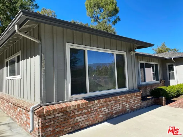 a view of a house with a yard and potted plants
