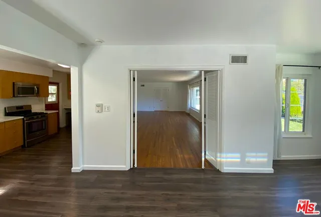 a kitchen with stainless steel appliances granite countertop a sink a stove top oven a counter space and cabinets