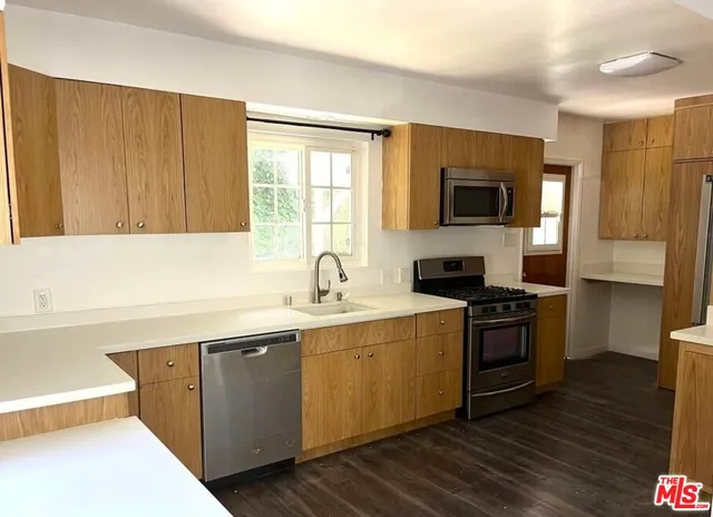 a kitchen with stainless steel appliances granite countertop a sink stove and microwave