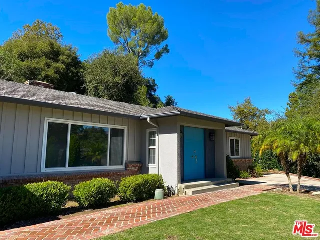 a view of a house with backyard and trees