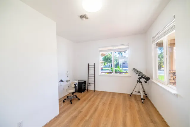 a view of a workspace with furniture and a window